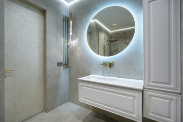 Modern bathroom design featuring elegant lighting and sleek fixtures in a spacious layout