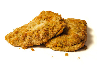 Fine breaded chicken breast fillet on white background. Classic poultry product. Uncooked meat covered with golden breadcrumbs.