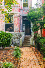 Charming brick home with fall foliage on the front path in a quiet Washington DC neighborhood.