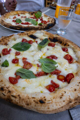 Eating of fresh baked Naples pizza dish in italian pizzeria restaurant, close up
