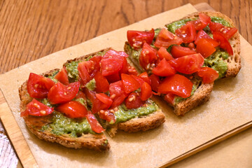 Starter in italian restaurants, bread bruschetta roasted homebaked bread with olive oil and chopped ripe tomatoes and pesto