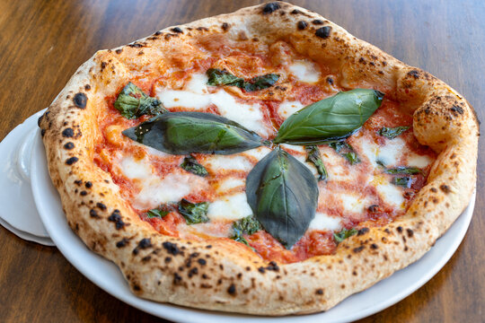 Sour dough pizza flat bread with mozzarella cheese, tomatoes and basil leaves Margarita, Napels street food, Italy