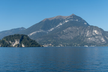 Views of lake Como with blue water, alpine mountains, beautiful villages, travel destination in North of Italy