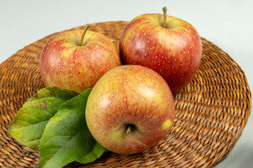New harvest of french sweet red green apples, tasty healthy fruits with green leaves