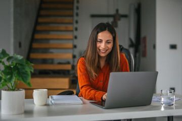 Professional woman working from home office using laptop