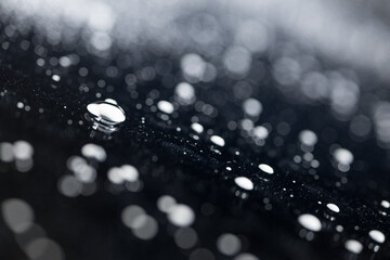 raindrops on a dark background.water drops on glass in close-up. Abstract dark background. Mockup for your logo. horizontal wallpaper or web banner.