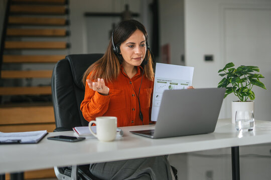 Woman teleconferencing, working remotely from home office - Powered by Adobe
