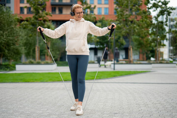 Mature woman training with resistance bands outdoors