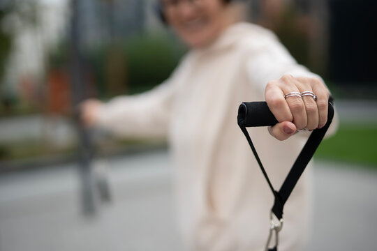 Senior woman exercising arm with rubber resistance band - Powered by Adobe