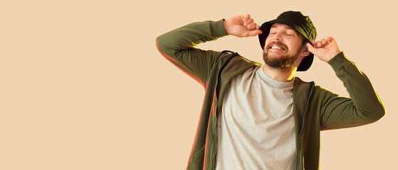 Handsome male hip-hop dancer on yellow background with space for text