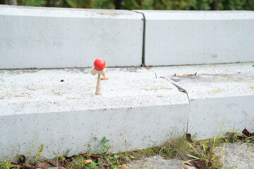 A small red ball is sitting on a cement step