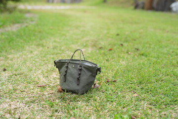 A small green purse is laying on the grass