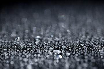 raindrops on a dark background.water drops on glass in close-up. Abstract dark background. Mockup for your logo. horizontal wallpaper or web banner.