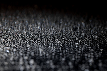 raindrops on a dark background.water drops on glass in close-up. Abstract dark background. Mockup for your logo. horizontal wallpaper or web banner.