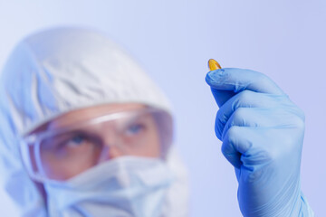 Scientist analyzing omega fish oil yellow capsules in protective gear with focused precision