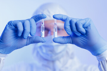 Worker making quality control of glass slide ampoule with vaccine vs virus in pharmaceutical...