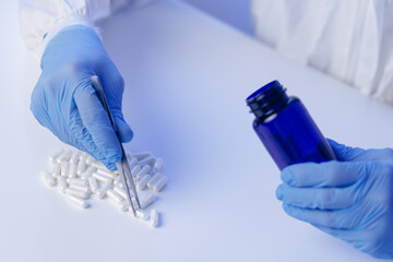 Closeup Healthcare worker ensuring tablet quality in pharmaceutical production, blue light.