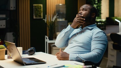 African american staff member distraught thinking about new ideas to impress the board, creating a...