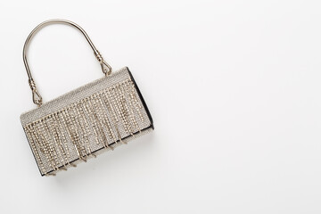 Handbag with beads on color background, top view