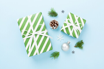 Striped Christmas gift boxes on color background, top view