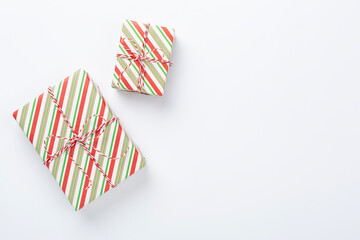 Striped Christmas gift boxes on color background, top view