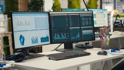 Empty corporate office features high tech technology and dual monitors, analytics tools ready for...