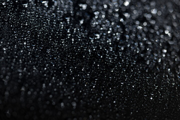 raindrops on a dark background.water drops on glass in close-up. Abstract dark background. Mockup for your logo. horizontal wallpaper or web banner.