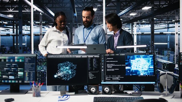 Happy data center coworkers monitoring neural network AI LLM visualization. Jolly workers in high tech facility using devices to oversee servers powering machine learning processes, camera A