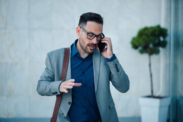 Businessman making a phone call outside office building