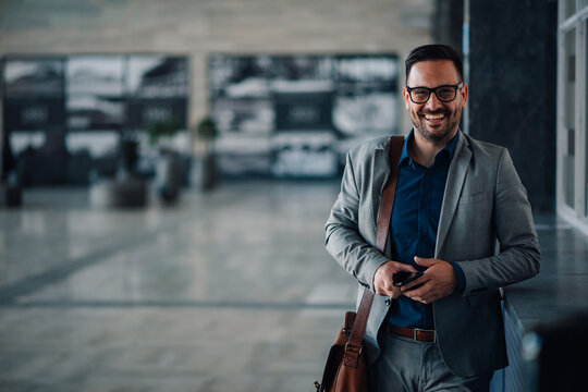 Confident businessman smiling in modern office lobby