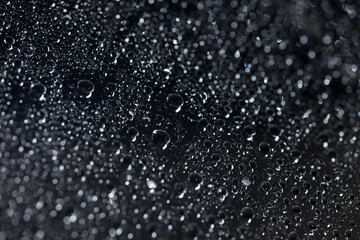 raindrops on a dark background.water drops on glass in close-up. Abstract dark background. Mockup for your logo. horizontal wallpaper or web banner.