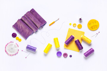 Set of thread spools with fabric and sewing supplies on white background
