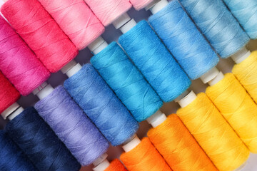 Colorful thread spools as background, closeup