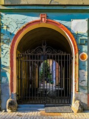 Colorful arched gate with metal doors on an old European building facade