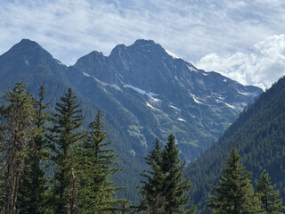 Obraz premium Glacier view framed by leafy trees in Ross Lake North Cascades National Park.USA, Washington july 19 2025.