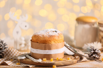 Christmas Panettone with candied fruit on table against blurred lights, closeup