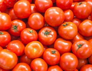 Close-up view of fresh, ripe, red tomatoes with their green stems, arranged in a pile