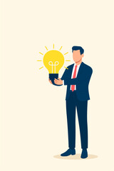 Young Businessman Holding a Big Light Bulb Symbolizing Bright Idea and Innovation