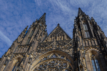 Fototapeta premium Beautiful aerial and detailed view of St. Vitus Cathedral in Prague Castle, Czech Republic, showcasing Gothic architecture, gargoyles, stained glass, and the historic city skyline.