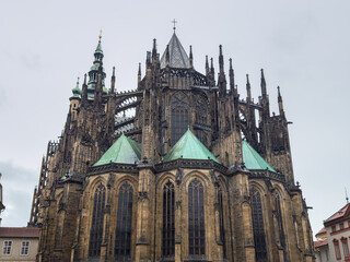 Fototapeta premium Beautiful aerial and detailed view of St. Vitus Cathedral in Prague Castle, Czech Republic, showcasing Gothic architecture, gargoyles, stained glass, and the historic city skyline.
