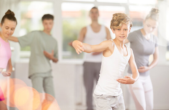 Girls and boys are learning various dance and ballet movements in the studio