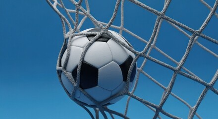 Naklejka premium A close-up shot of a soccer ball nestled inside a goal net against a blue sky