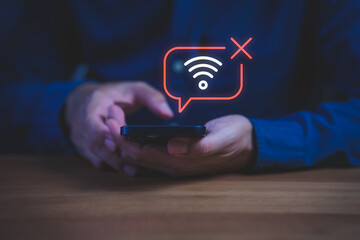 Close-up of hand holding smartphone with no Wi-Fi connection icon, symbolizing internet...