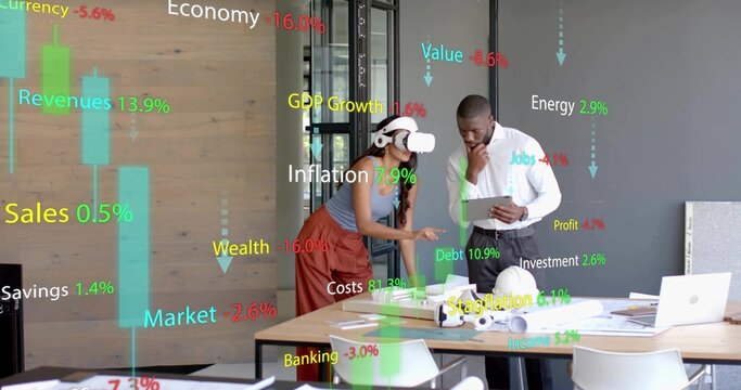 Woman wearing VR headset and colleague using tablet in meeting room, with models and data charts