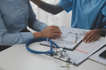 Asian doctor woman visited patient woman to diagnosis and check up health at home or private hospital. Female patient explain health problem and symptoms to doctor .Health care premium service at home