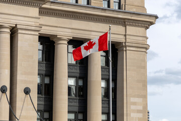 Canadian national flag waving near the Senate of Canada building.