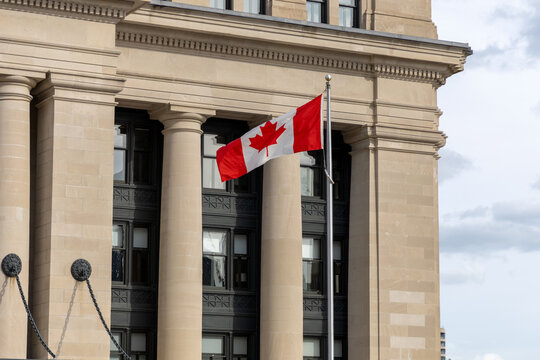 Canadian national flag waving near the Senate of Canada building.