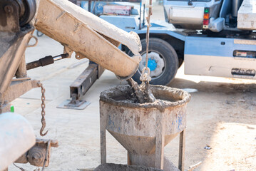 Mixer truck filling a concrete to crane bucket.