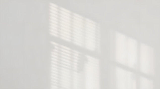 Soft sunlight casting geometric shadows on a white wall
