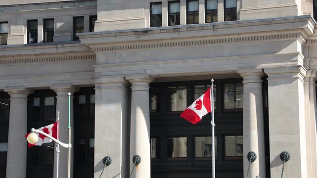Canadian national flag waving near the senate of canada building. 